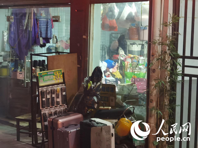 南宁“城中村”一裁缝铺老板将电线从店内拉出为电动自行车充电。人民网 覃心摄